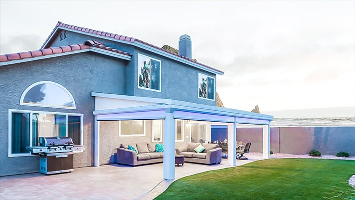 Modern Gray Home with a Large Patio that is Covered by a LifeRoom Enclosure with a Lush Green Yard Next to It   